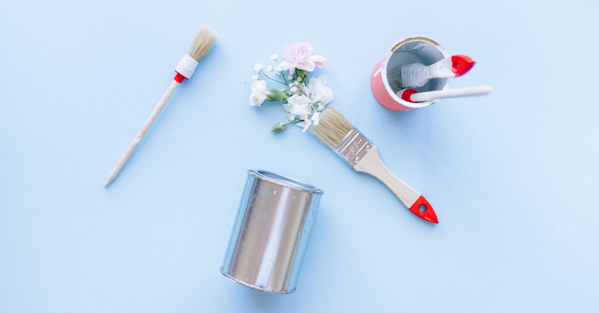 Open paint cans and a brush