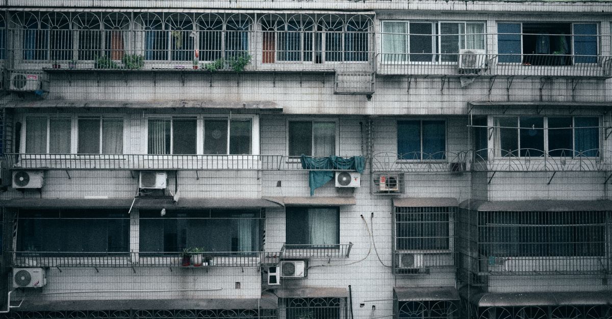 An older AC condenser beside a home