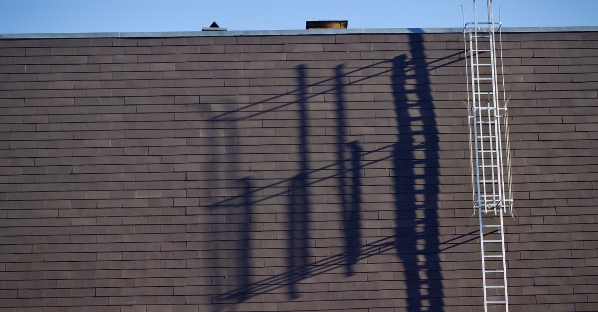 A roofer inspecting shingles