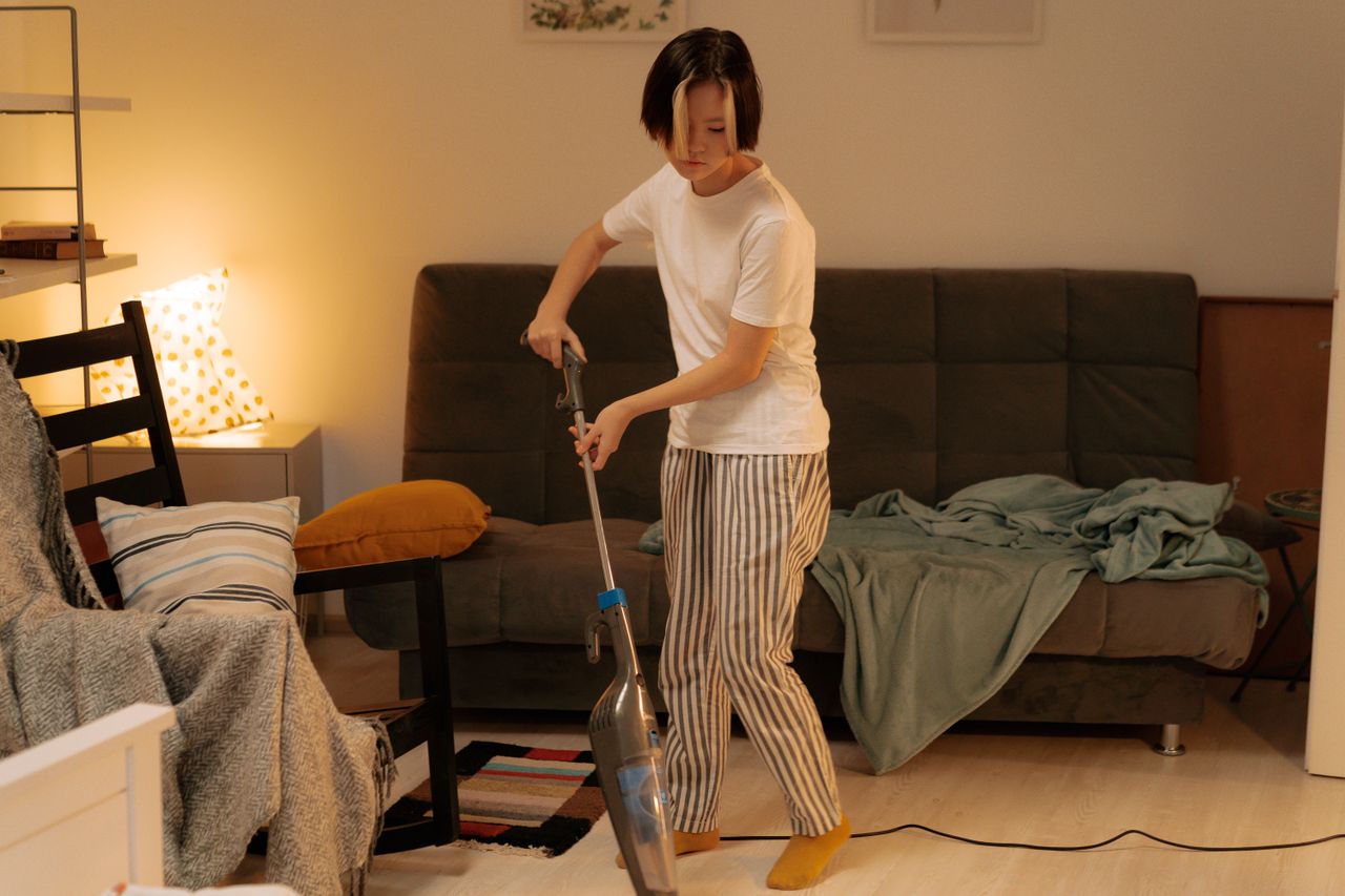 A person vacuuming a tidy living room