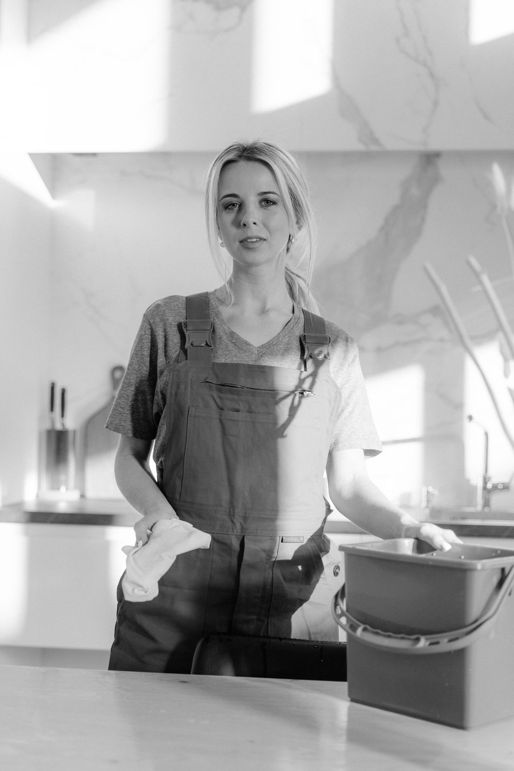 A professional cleaner with a bucket in a modern kitchen