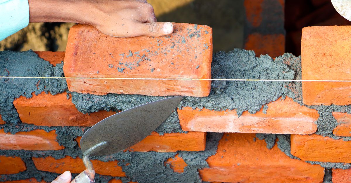 A mason laying brick on a project