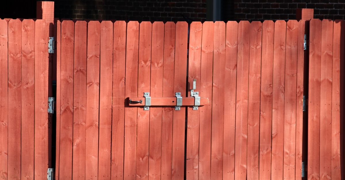 A new wood fence being installed in a backyard