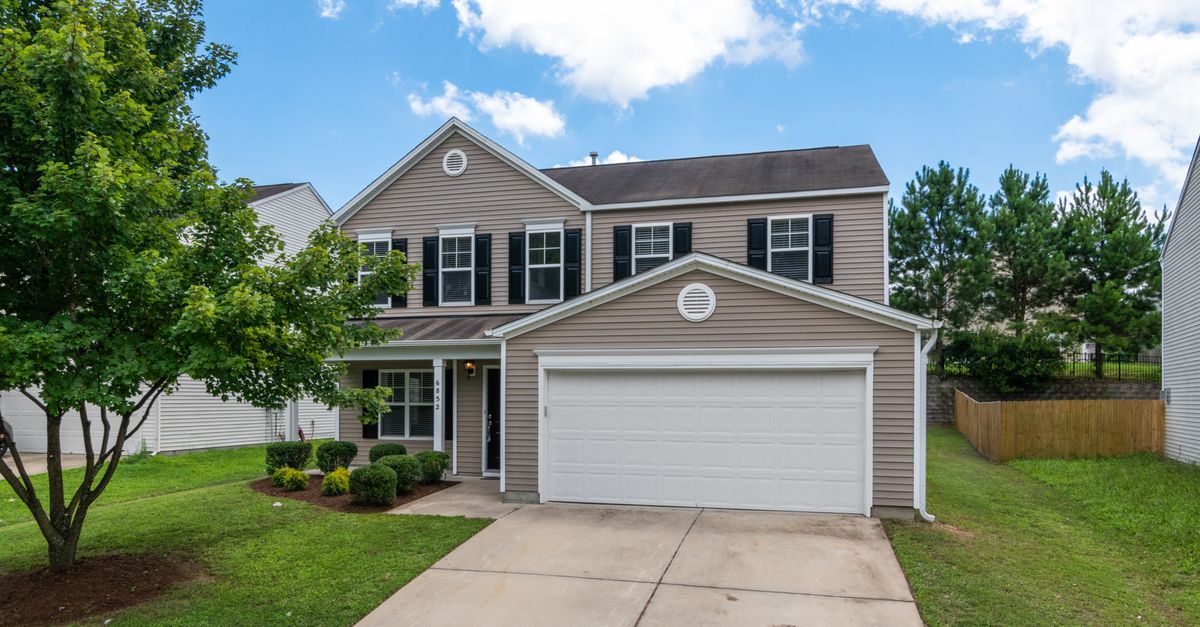 A white vinyl fence beside a home