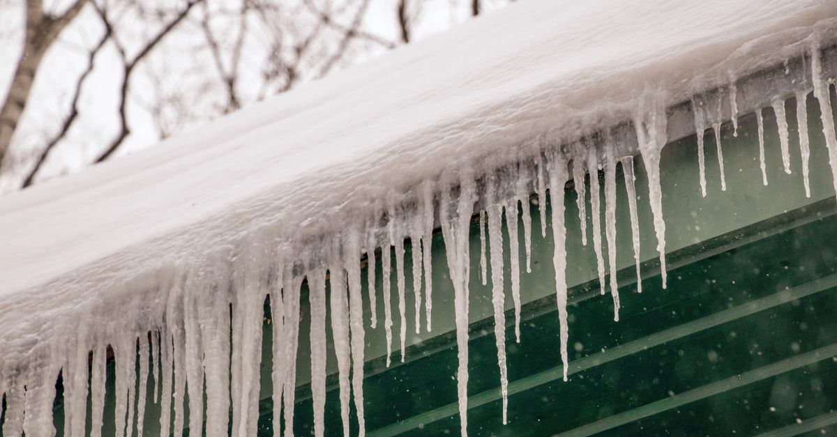 Icicles hanging from a roof eave, a sign of ice dams