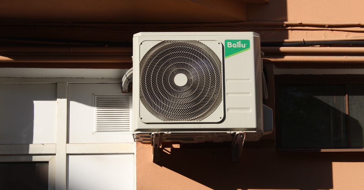 An outdoor AC condenser unit beside a house