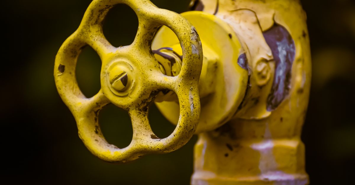 A hand turning a home water shutoff valve