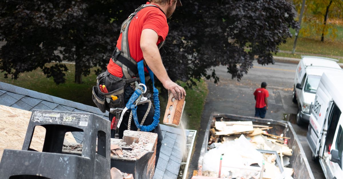 A roofing contractor at work on a house