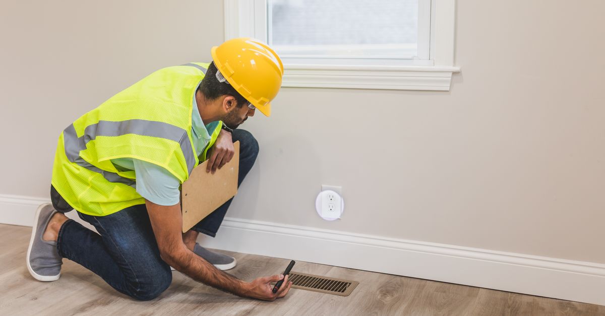 A flooring contractor measuring a room for tile