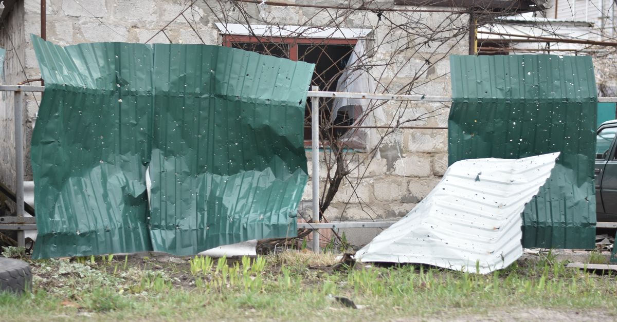 A damaged and leaning fence panel