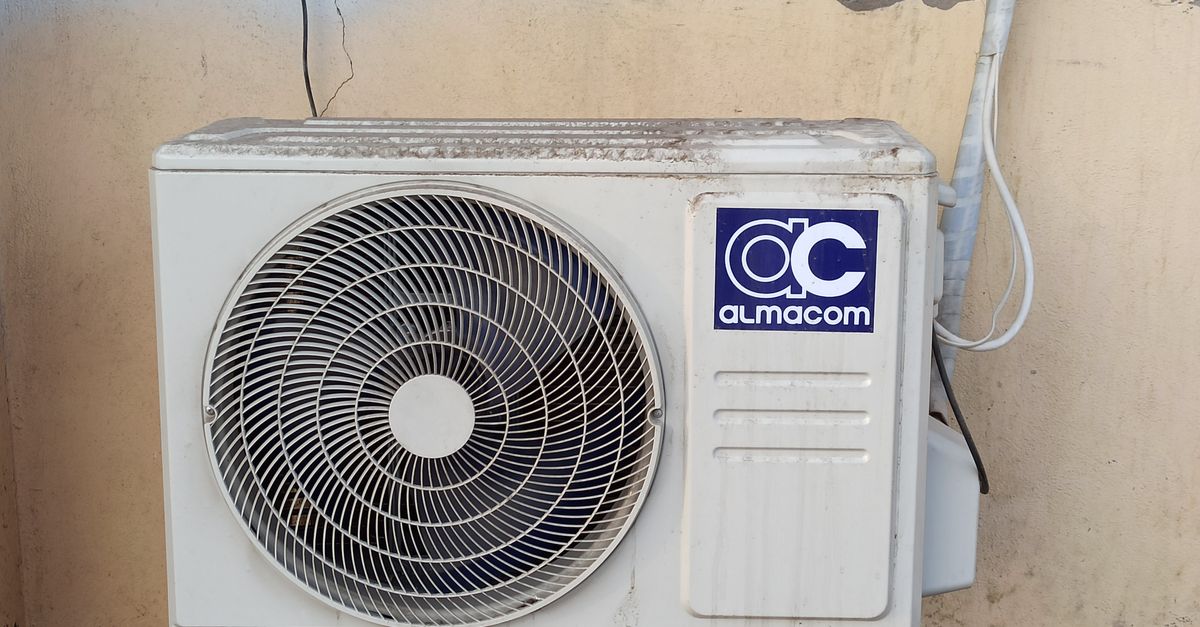 An outdoor AC condenser unit beside a house