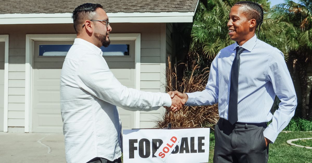 A homeowner shaking hands with a contractor